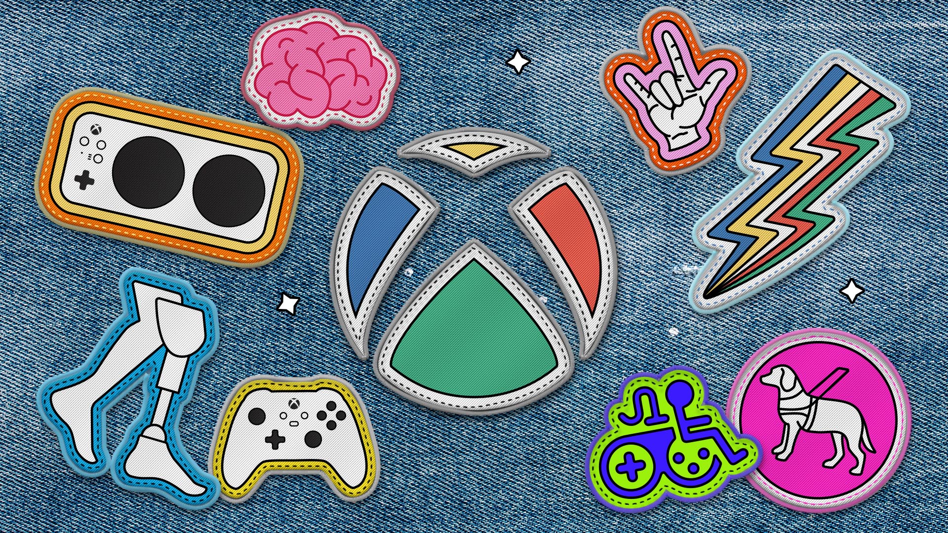 O logotipo do Xbox como um patch costurado em uma jaqueta jeans. O logotipo do Xbox é cercado por outras versões de patches de logotipos de acessibilidade, incluindo o Controle Adaptável do Xbox, o Game Accessibility Joyrider, o logotipo do orgulho da deficiência e mais